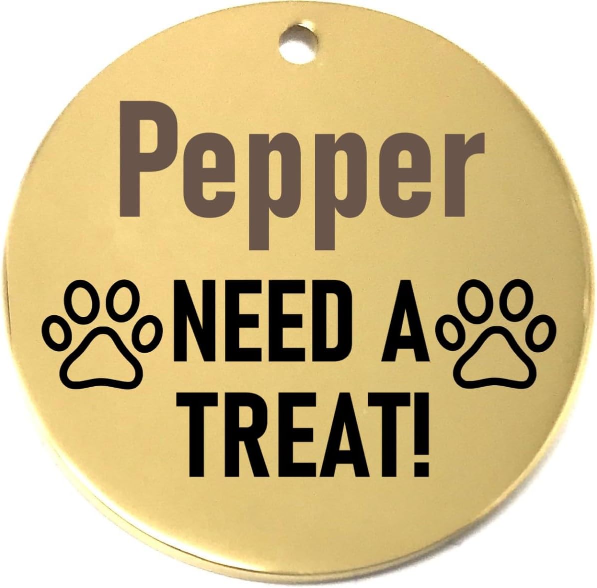 Gold pet name tag with 'Pepper NEED A TREAT!' text and paw prints on a white background
