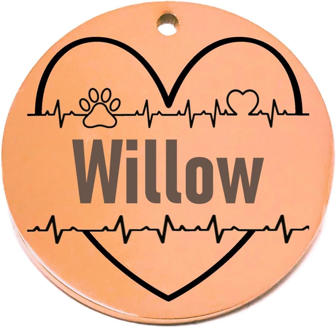 Round rose gold pet tag with 'Willow' and heart designs on a white background