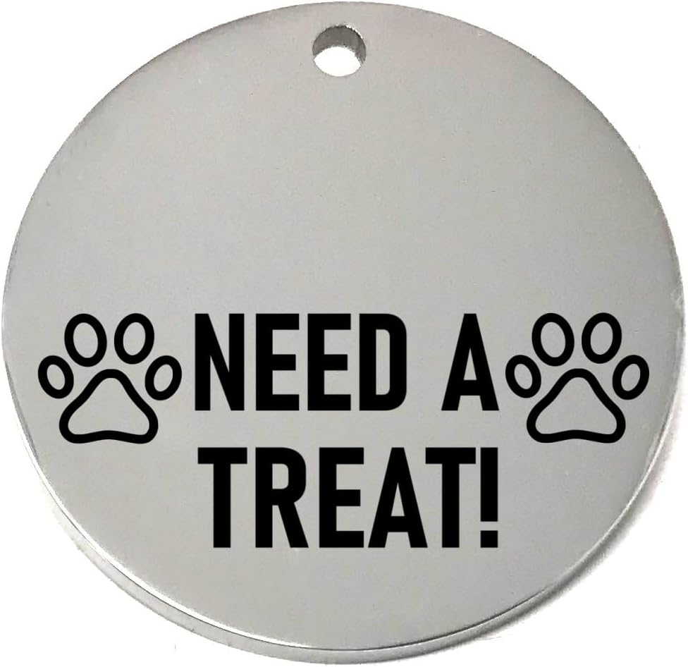 Round silver pet name tag with 'NEED A TREAT!' text and paw prints on a white background